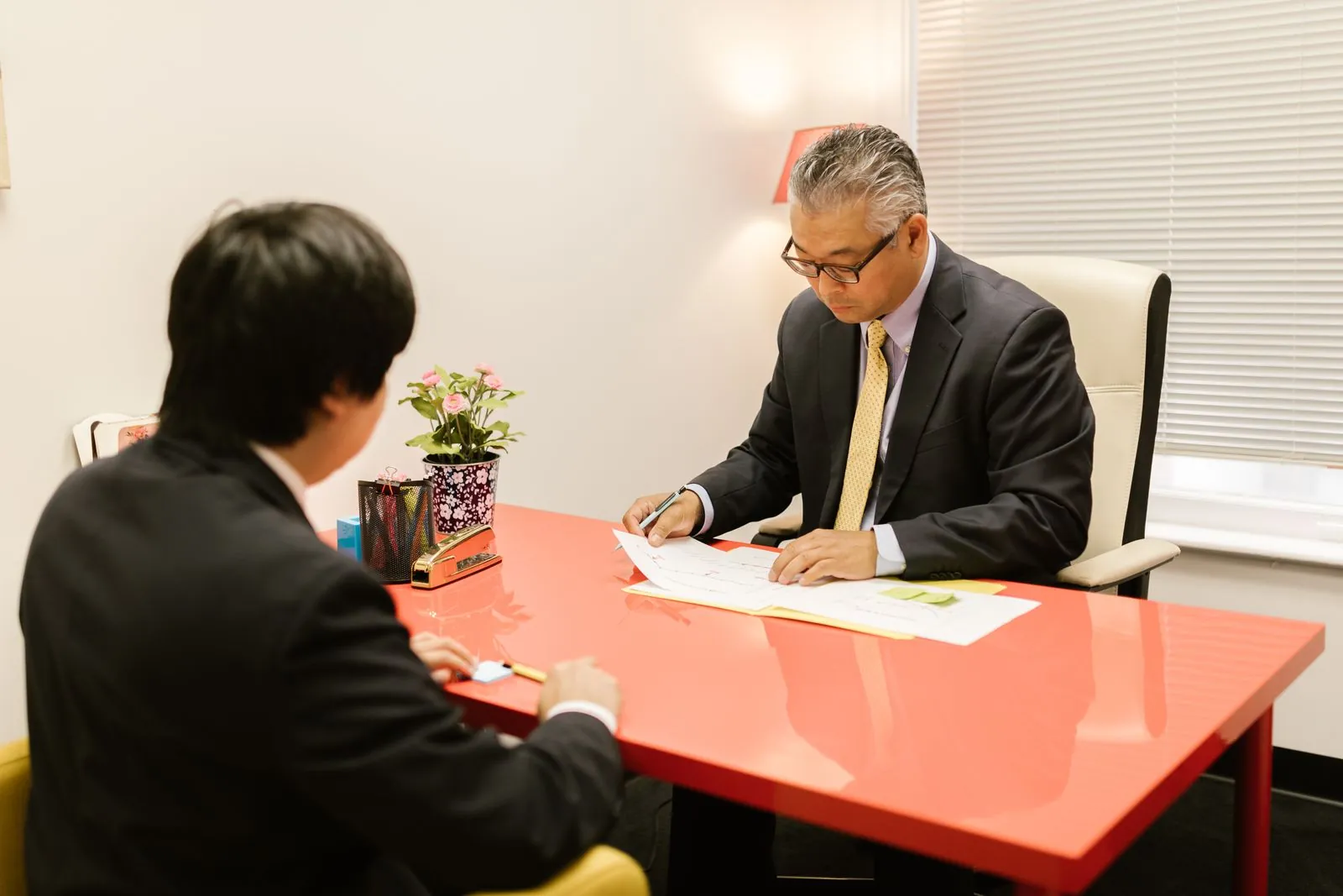 机をはさんで契約内容を確認している二人